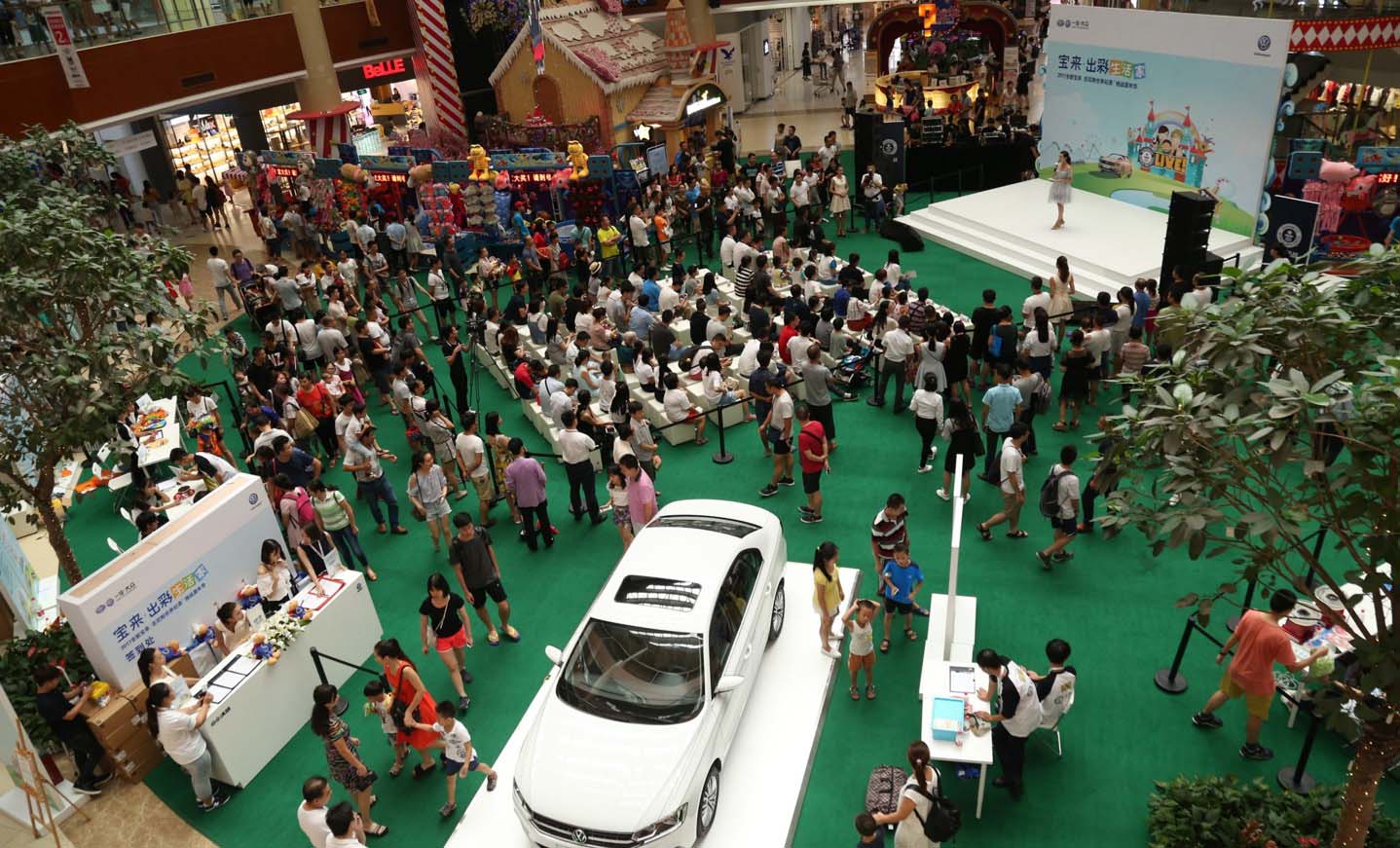live show with crowds of people are a white car 