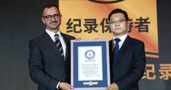 adjudicator next to man in suit holding gwr certificate