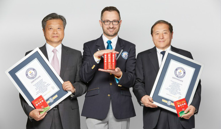 adjudicator next to two men in suits holding gwr certificates