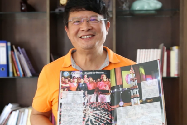 man holding up magazine while smiling