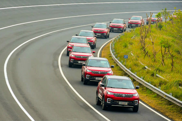 several red cars driving behind each other