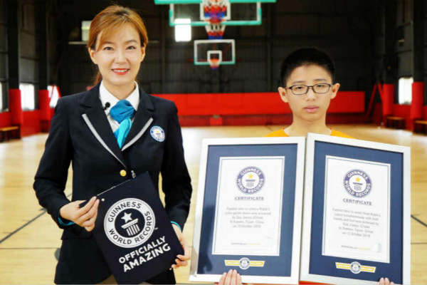 young kid holding two gwr certificates next to adjudicator