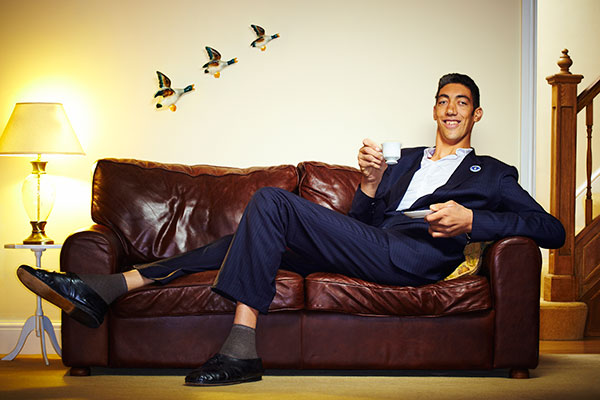 sultan in a suit sitting down on sofa
