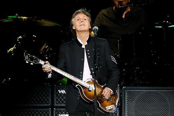 Paul McCartney smiling and playing